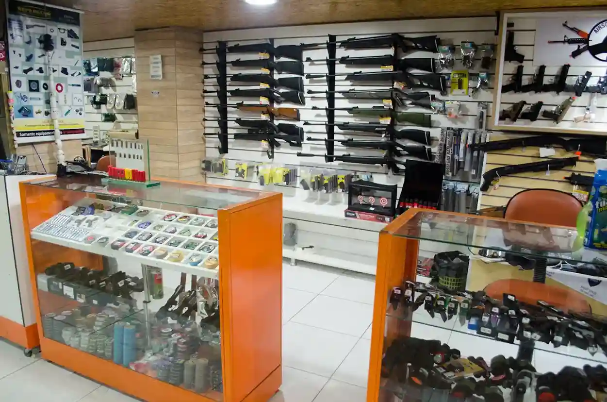 Balcão e parede com carabinas e acessórios na loja