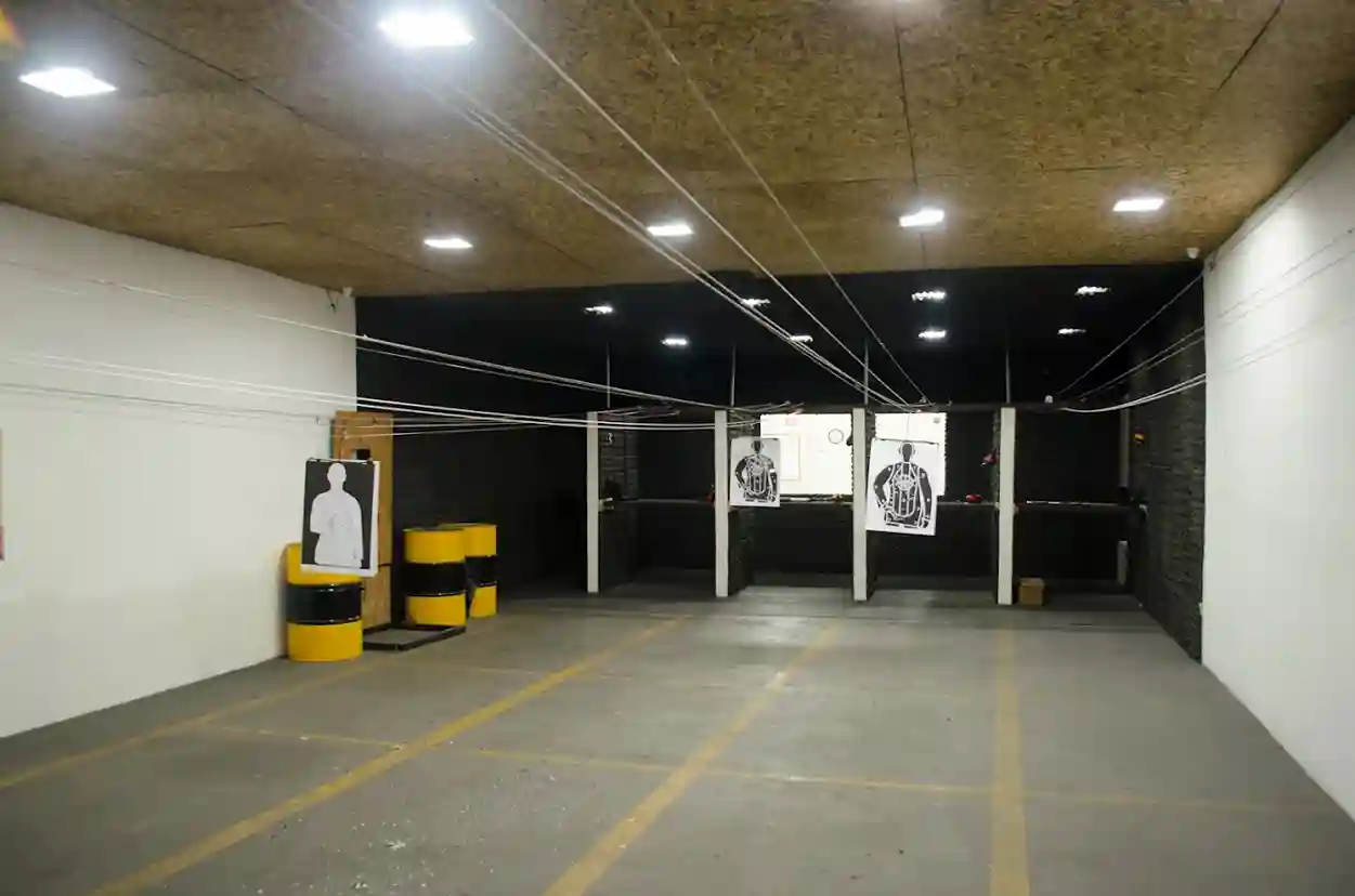 Estande de tiro interno com raias, alvos e iluminação profissional